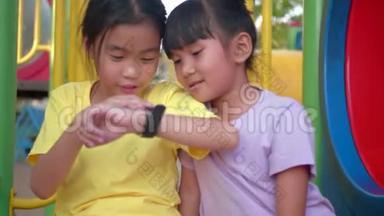 亚洲<strong>儿童</strong>`女孩在操场外使用她的智能<strong>手表</strong>装置。